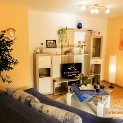 Helles und gemütliches Wohnzimmer der Ferienwohnung Ilona in Zweibrücken mit moderner Wohnwand, Sofa, dekorativem Couchtisch und stimmungsvoller Beleuchtung – ideal zum Entspannen.